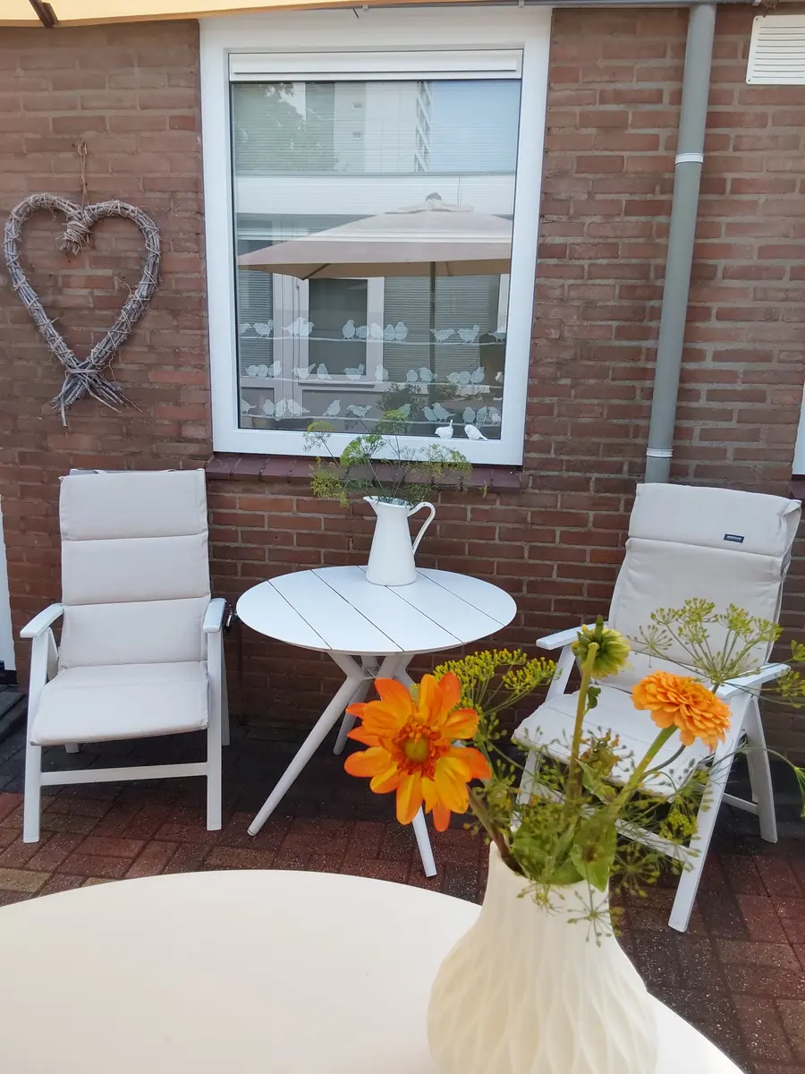 Privéterras met zitje en bloemen bij de B&B in Emmen